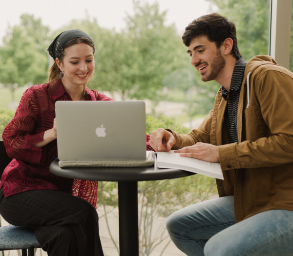 Students laughing over computer.